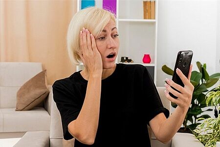 Frau erschrocken mit smartphone in der Hand